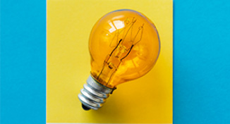 Image of Light bulb against yellow square background